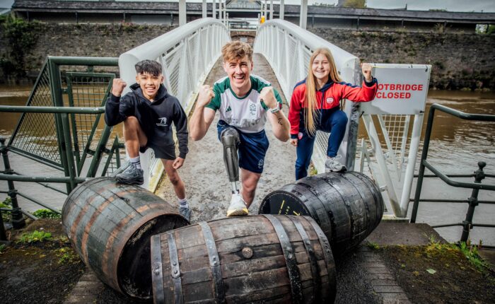 A young gymnast boy, Paralympian rower young man, and teen girl soccer player try out the traditional sport of French Barrel Rolling