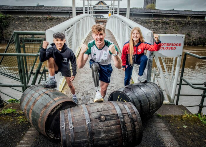 A young gymnast boy, Paralympian rower young man, and teen girl soccer player try out the traditional sport of French Barrel Rolling